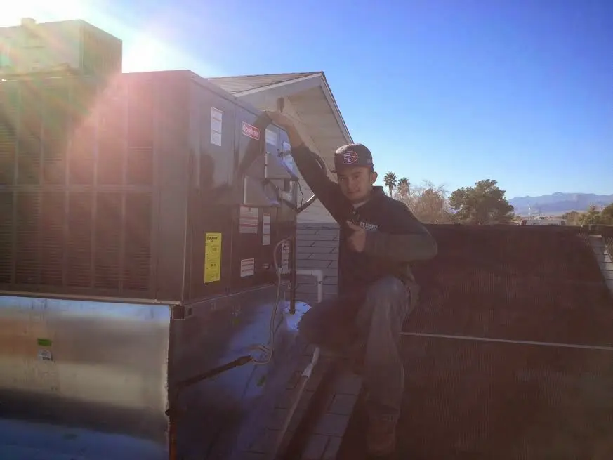 HVAC technician performing Heat Pump Repair on a rooftop unit in Maple Valley